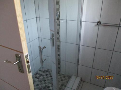 a bathroom with a shower with a glass door at PS GOOD TIME GUEST HOUSE in Klerksdorp