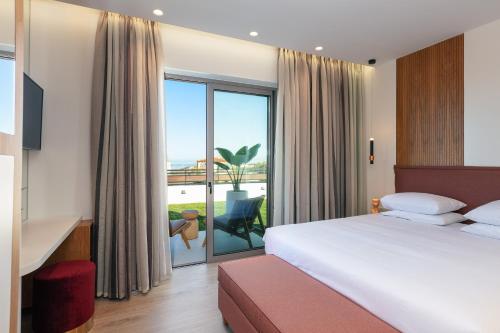 a hotel room with a bed and a large window at Macaw Luxury Residence, daily housekeeping included! in Skaleta