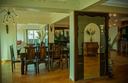 a dining room with a table and chairs and a mirror at Zamalek X Hostel-Nile view in Cairo