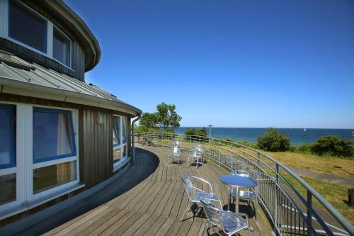 a deck with chairs and tables on a building at Jugendherberge Dahme in Dahme