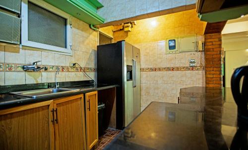 a small kitchen with a sink and a refrigerator at Zamalek X Hostel in Cairo