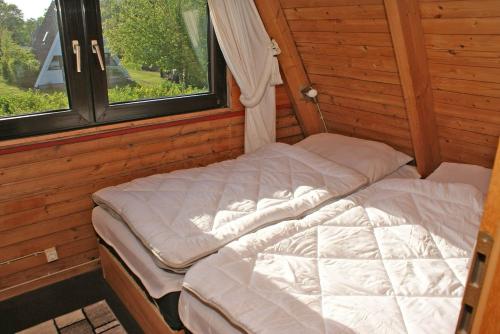 a bed in a room with a window at Zeltdachhaus mit W_LAN _ Parkplatz in Damp