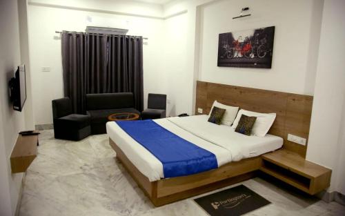 a bedroom with a bed and a chair in it at Hotel Nisha Nest, Bhopal in Bhopal