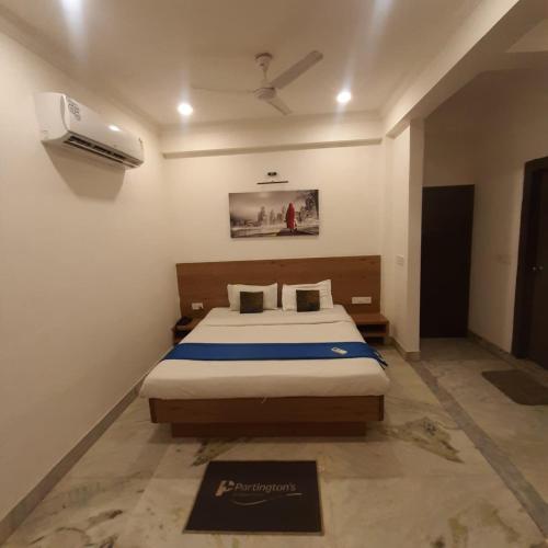 a bedroom with a bed and a air conditioner at Hotel Nisha Nest, Bhopal in Bhopal