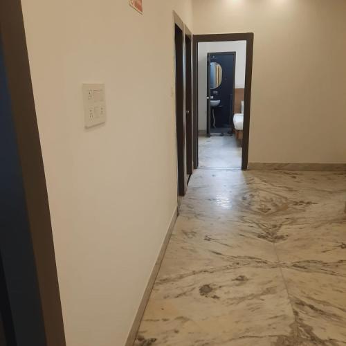 a hallway with a marble floor and a light switch at Hotel Nisha Nest, Bhopal in Bhopal