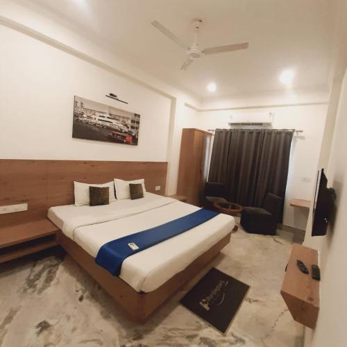 a bedroom with a bed and a chair in it at Hotel Nisha Nest, Bhopal in Bhopal
