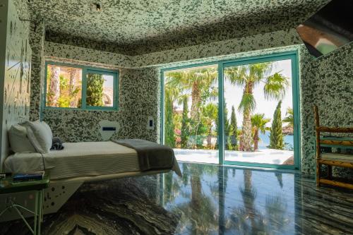 a bedroom with a bed and a large window at Calilo in Manganari