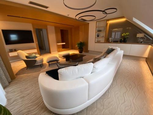 Normafa Hotel في بودابست: غرفة معيشة مع أريكة بيضاء وتلفزيون
