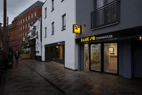 una calle vacía con un hombre caminando delante de una tienda en Bank Square Town House, en Belfast