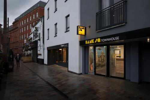 an empty street with a man walking in front of a store at Bank Square Town House in Belfast