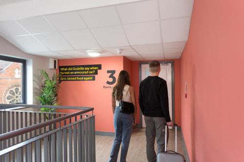 a man and a woman standing in a hallway at Bank Square Town House in Belfast