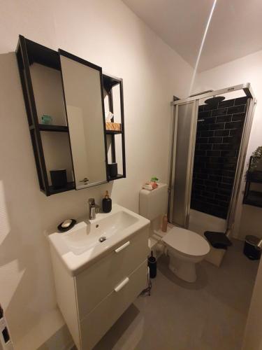 a bathroom with a white sink and a toilet at Modernes Apartment zentral in Bad Laasphe