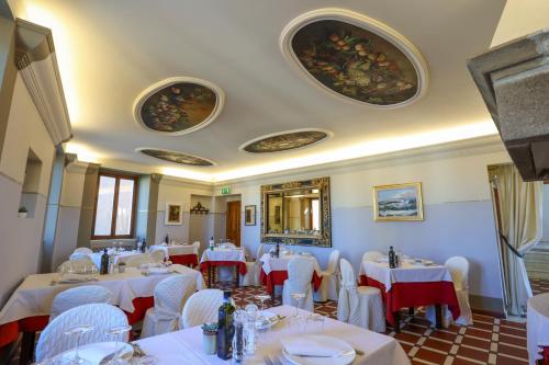 a dining room with white tables and white chairs at Albergo Diffuso Borgo Montemaggiore in Montemaggiore al Metauro
