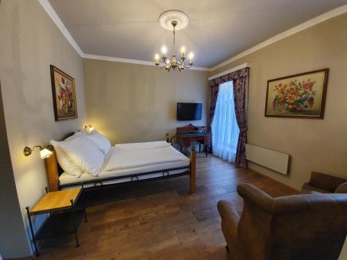 - une chambre avec un lit et un canapé dans l'établissement Lesní Hotel Peršlák, à Nová Bystřice