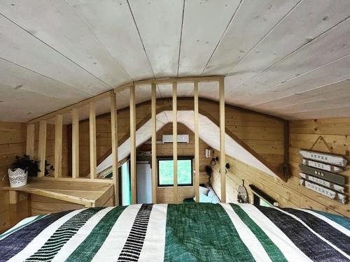 sypialnia z łóżkiem w drewnianym pokoju w obiekcie Tiny House 