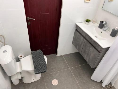 a bathroom with a white toilet and a sink at Lord of the Dead Sea by CROWN in Neve Zohar