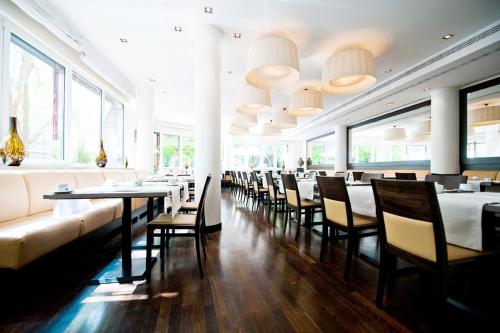 a dining room with tables and chairs and windows at Bristol Hotel - Frankfurt City in Frankfurt/Main