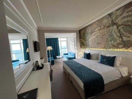 a hotel room with a bed and a large painting on the wall at Adriatik Hotel, BW Premier Collection in Durrës