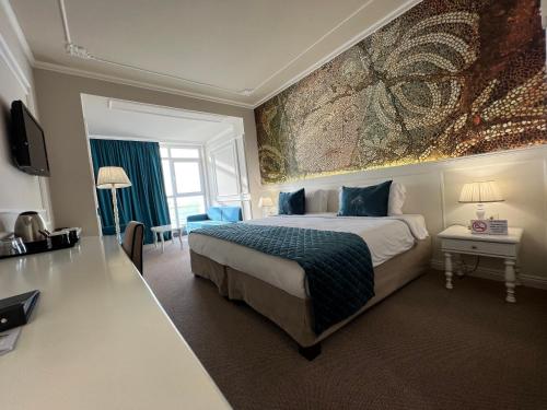 a bedroom with a bed and a large painting on the wall at Adriatik Hotel, BW Premier Collection in Durrës