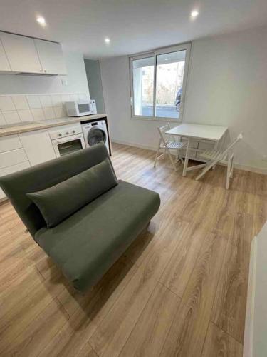 un salon avec un canapé vert et une table dans l'établissement Appartement neuf tout confort à Blaye proche de la Citadelle, à Blaye