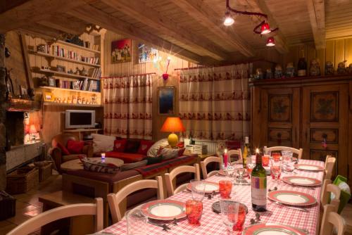a dining room with a table and chairs and a couch at Chalet Mokus in Les Allues