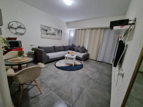 a living room with a couch and a table at Pearl island suite in Ashqelon