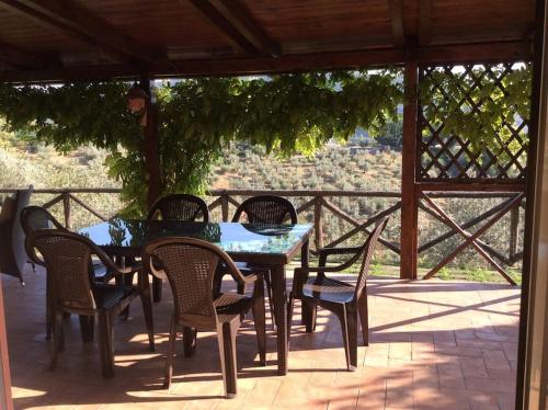 einen Tisch und Stühle auf einer Terrasse mit Aussicht in der Unterkunft Villa Panoramica con piscina in Castelnuovo di Farfa