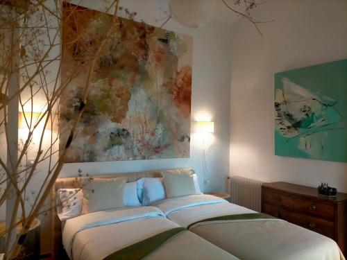 een slaapkamer met 2 bedden en een schilderij aan de muur bij El Telar Arte y Naturaleza in Prádena