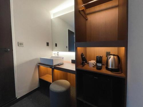 a kitchen with a sink and a coffee maker on a counter at Pillowsopher Hongdae in Seoul