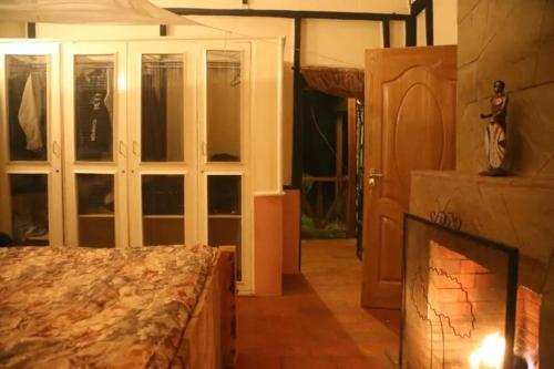 1 dormitorio con 1 cama y chimenea en Dwardos Cottage - Serene Private Cottage w/Wi-Fi, en Nyeri