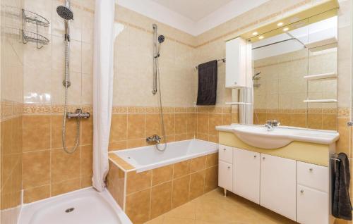 uma casa de banho com uma banheira, um lavatório e um chuveiro em Nice Home In Kastav With Wifi em Kastav