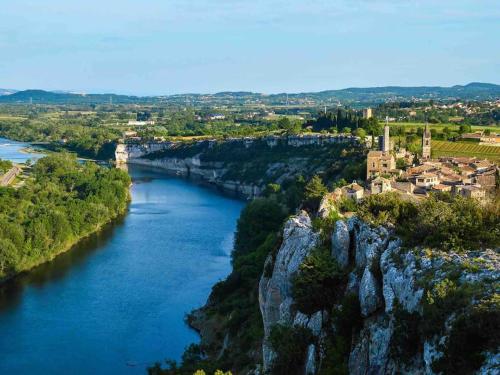 a river with a castle on top of a cliff at Appartement neuf avec Spa in Saint-Martin-dʼArdèche