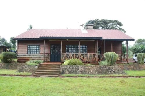 a log cabin with a porch and a yard at Dwardos Cottage - Serene Private Cottage in Nyeri