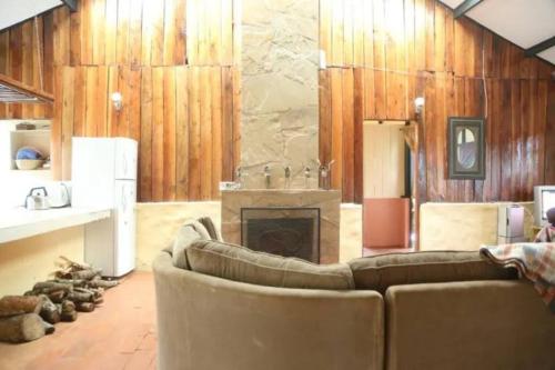 a living room with a couch and a fireplace at Dwardos Cottage - Serene Private Cottage w/Wi-Fi in Nyeri