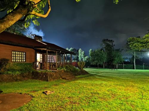 uma casa num parque à noite em Dwardos Cottage - Serene Private Cottage w/Wi-Fi em Nyeri