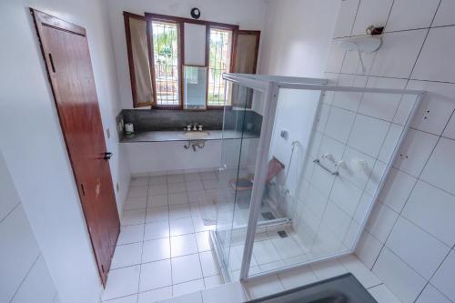 uma casa de banho com uma cabina de duche em vidro e um lavatório. em Pousada Recanto de Itacuruçá em Itacuruçá
