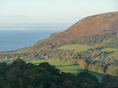 an aerial view of a mountain with a lake at The Pack Horse Exmoor National Park Allerford Riverside Cottage & Apartments in Minehead