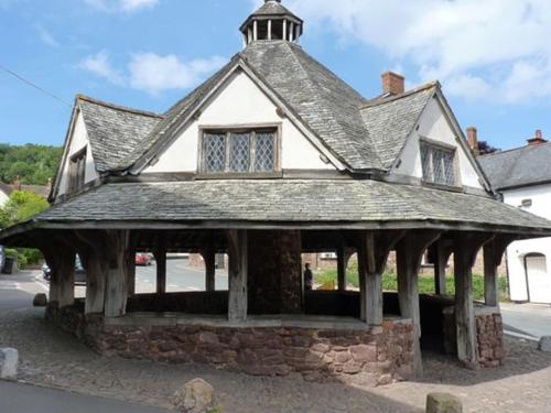an old building with a roof on a street at The Pack Horse Exmoor National Park Allerford Riverside Cottage & Apartments in Minehead
