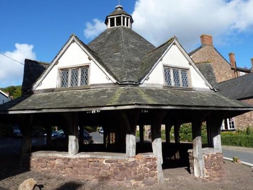 a large white house with a black roof at The Pack Horse Exmoor National Park Allerford Riverside Cottage & Apartments in Minehead