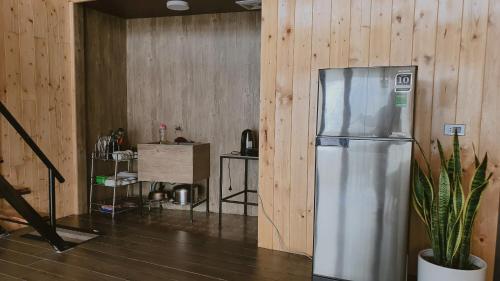 a stainless steel refrigerator in a room with wooden walls at Bách Xanh House - Cloud Bungalow in Vĩnh Phúc