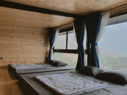 two beds in a room with two windows at Bách Xanh House - Cloud Bungalow in Vĩnh Phúc
