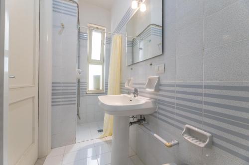 bagno bianco con lavandino e doccia di Residence Caletta a Marina di Mancaversa