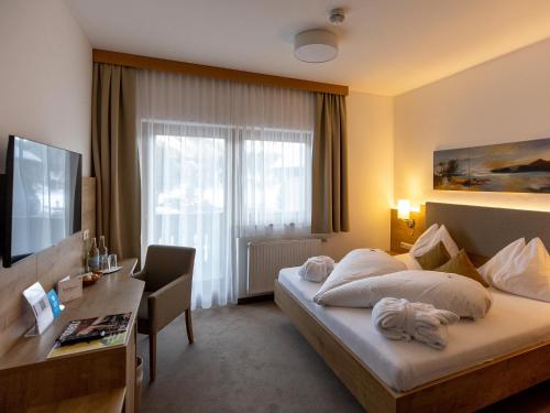 a hotel room with a bed and a desk at Hotel Turracherhof in Turracher Hohe