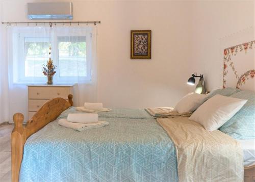 Schlafzimmer mit einem Bett mit blauer Decke in der Unterkunft Birslak in Makkoshotyka