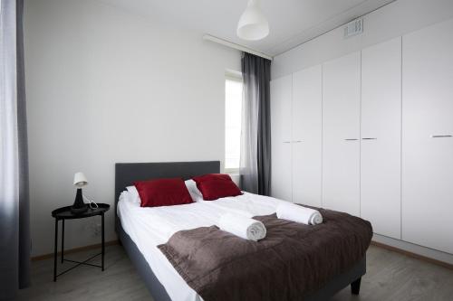 - une chambre avec un lit doté d'oreillers rouges dans l'établissement New apartment, two bed room, free car park, à Turku