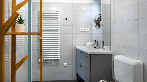 ein weißes Bad mit einem Waschbecken und einem WC in der Unterkunft Birslak in Makkoshotyka