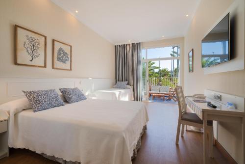 a hotel room with a bed and a desk and a room at VIK Hotel San Antonio in Puerto del Carmen