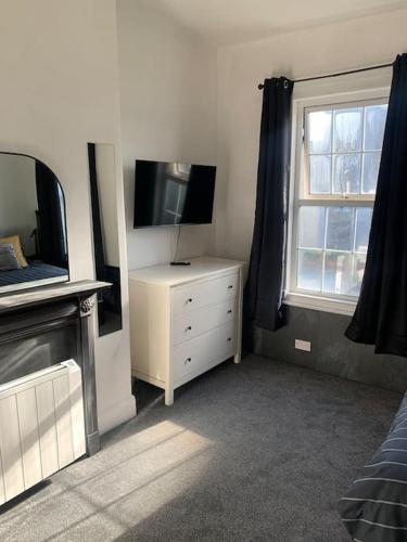 ein Wohnzimmer mit einem TV und einer Kommode mit einem tvicterictericter in der Unterkunft Number 11 in Exeter