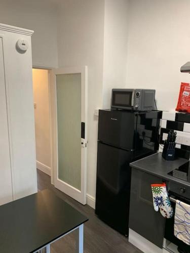 a kitchen with a black refrigerator and a microwave at Number 11 in Exeter