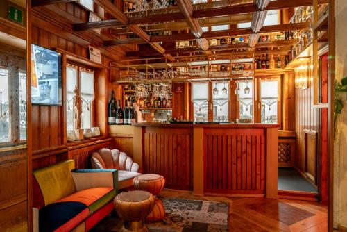 um quarto com um bar com um sofá e cadeiras em Ambra Cortina Luxury&Fashion Hotel em Cortina dʼAmpezzo